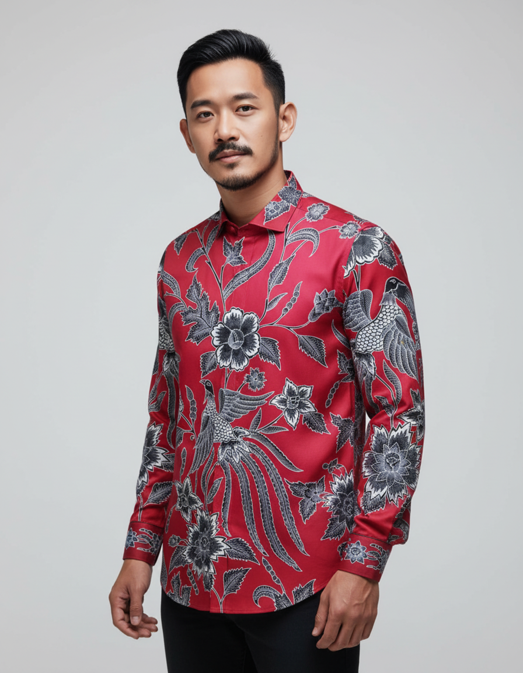 Kemeja batik tulis sutra merah dengan motif burung Cendrawasih dan flora abu-abu, memancarkan kesan mewah dan berwibawa.